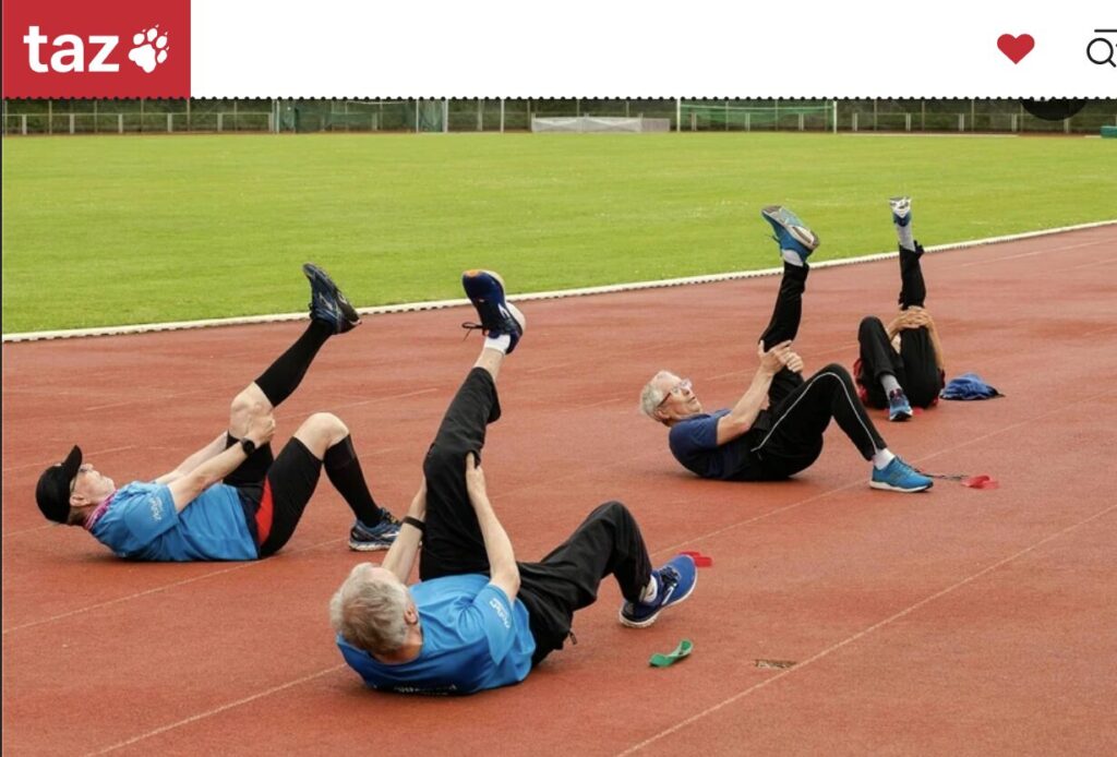 Männer beim Dehnen auf einem Sportplatz
