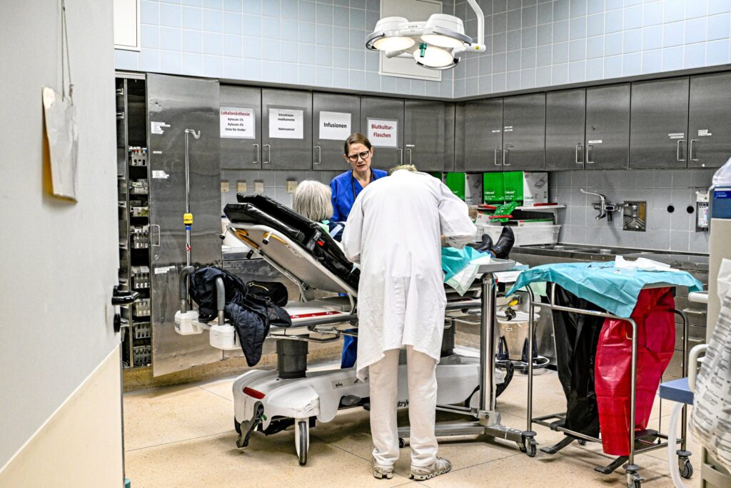 Ein Schockraum einer Notaufnahme mit verschiedenen Personen in Berufskleidung um eine Patientin